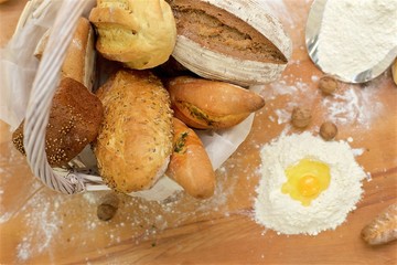 Many mixed breads in basket on the table, shot from above