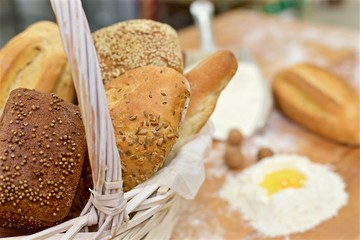 Many mixed breads in wicker basket on the table