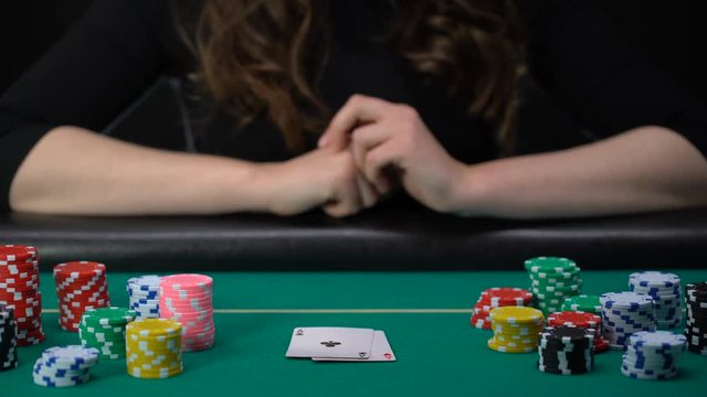 Lucky lady player showing hand, aces pair combination, poker competition, casino