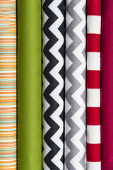 Colorful fabric scarves in stack as background 