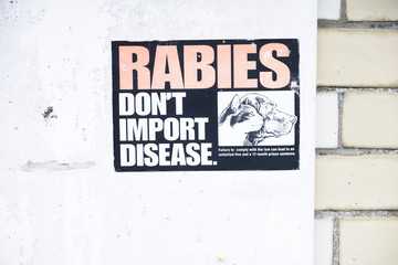 Rabies do not import disease sign on wall at customs port harbour
