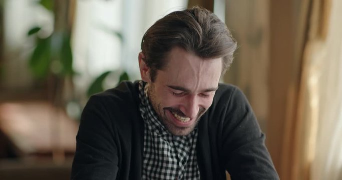 Man laughing while remembering funny memories