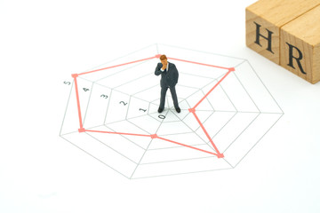 Fototapeta premium Miniature people businessmen standing on a Circle graphs of various skill levels. The concept used in selecting personnel to participate in the organization. with copy space.