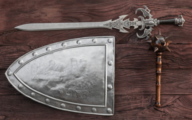 ancient weapon, shield and sword, wooden background