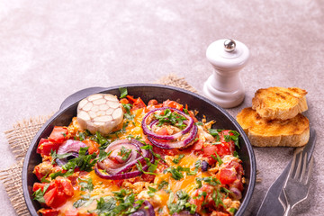 Shakshuka with toasts. Fried eggs with tomatoes, vegetables and herbs