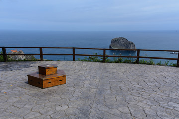A viewpoint showing the atlantic ocean, a little rocky island & san juan de gaztelugatxe at the...