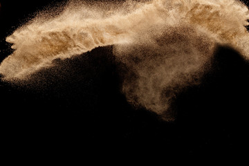 Dry river sand with stone explosion. Yellow colored sand splash agianst dark background.