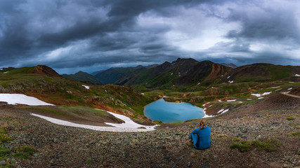 Tourist admires view from Hurricane Pass towards lake Como and Poughkeepsie Gulch