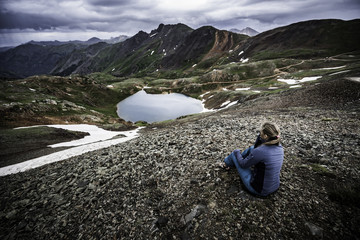 Tourist admires view from Hurricane Pass towards lake Como and Poughkeepsie Gulch
