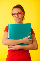Young geek woman in red t shirt over vibrant yellow background  under stress