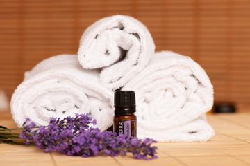White towels and massage rocks in spa salon over dark and light bamboo background