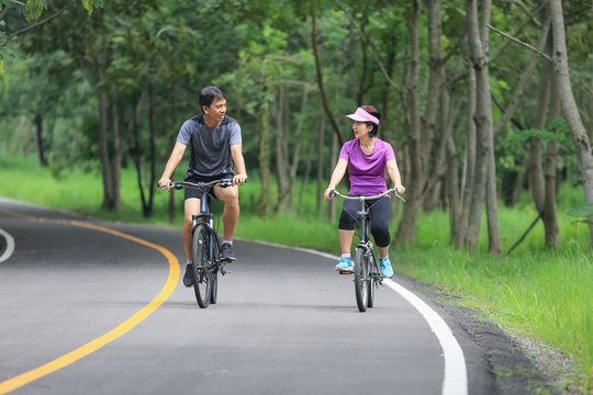 Middle aged couple relaxing exercise with bicycle in park