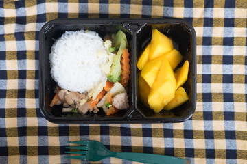 Rice and vegetables served with mango in lunch box