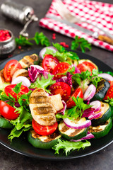 Salad with fresh and grilled vegetables and mushrooms. Vegetable salad with grilled champignons. Vegetable salad on plate. Healthy vegetarian food
