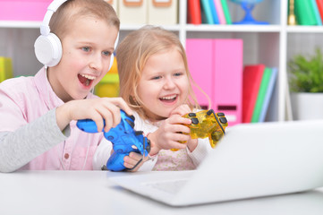 Cute little brother and sister using laptop