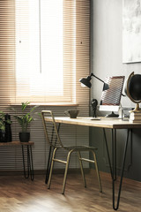 Real photo of hairpin desk with lamp, home office computer and coffee cup standing in living room...