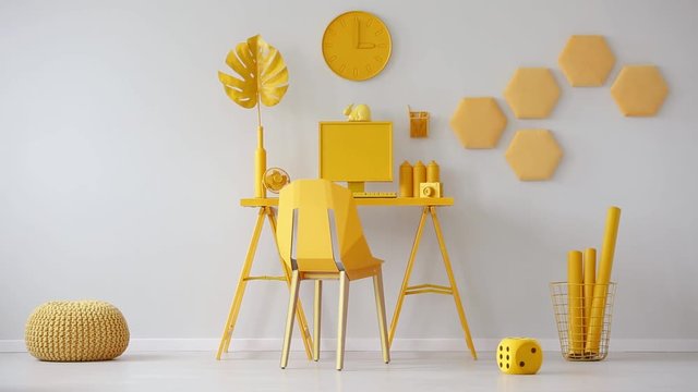 Plush dice in the video of a yellow room for a freelancer with computer on the desk and metal chair. Cinemagraph