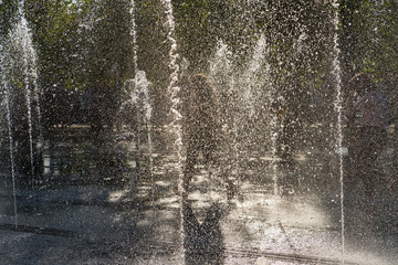 People running through fountain at summer time