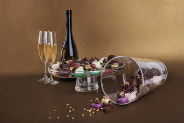 Different types of small chocolate sweets whit wine and candle