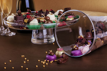 Different types of small chocolate sweets with white wine