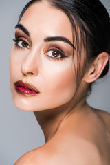 Fototapeta premium portrait of beautiful girl with makeup and red lips, isolated on grey