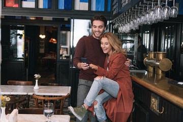 Funny video. Exuberant joyful couple using phone and laughing