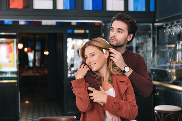 Moment of tenderness. Satisfied appealing couple hugging and staring aside