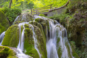 Fototapeta na wymiar Beautiful unique Bigar Waterfall in Romania on the Edge of the Road passing through the carpatian Mountains