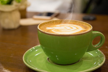 cup of hot coffee with foam and smoke on table in the morning. copyspace for your text