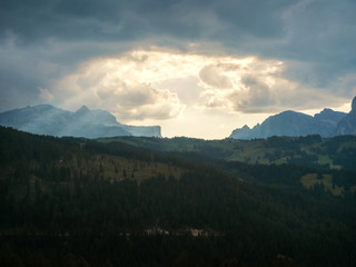 Fototapeta premium Sun beams and clouds at sunset over the mountains