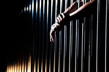 close up of prisoner hands in jail.