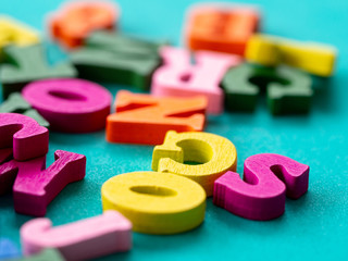 closeup of colorful wooden alphabet on green background.