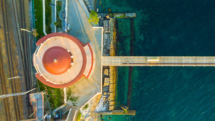 Top-down drone view of the Matsesta marine station near the railroad and the pier in sunny summer day, Sochi, Russia
