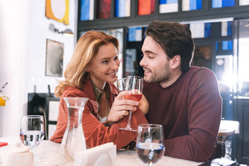 Tender reunion. Joyful cheerful couple drinking wine and communicating