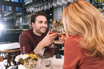 Five years together. Enthusiastic energetic couple drinking wine and dangling
