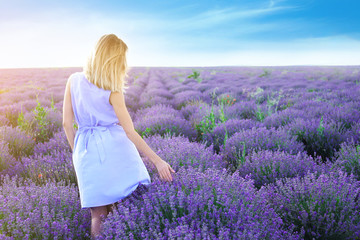 Fototapeta na wymiar Young woman in lavender field on summer day