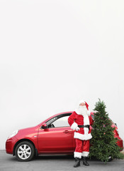 Authentic Santa Claus with Christmas tree near red car, outdoors