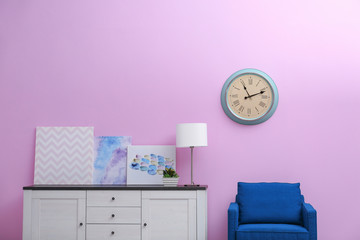 Room interior with stylish clock on wall. Time of day