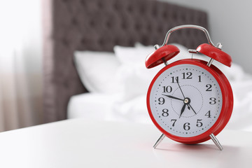 Alarm clock on table in bedroom. Time to wake up