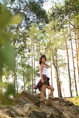 Young woman in beautiful forest on summer day. Camping season