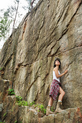 Young woman near steep cliff on summer day. Camping season