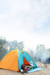 Camping tent and accessories in wilderness on summer day