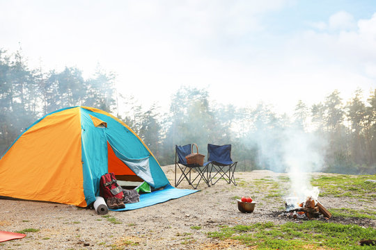 Camping tent and accessories in wilderness on summer day