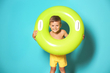 Naklejka premium Cute little boy with inflatable ring on color background
