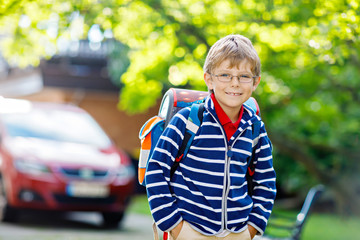little kid boy with school satchel on first day to school