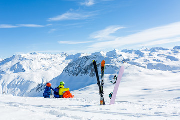 snowboarder and skiier sitting on snow and see at mountains