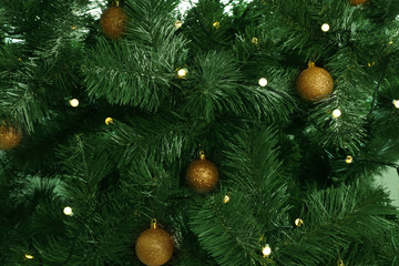 Fir tree with festive decor and glowing Christmas lights as background