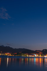 Night summer view on Alps mountains lake and Pilatus mountain, city glows, travel and vacation in Europe, embankment, Luzern, Switzerland, vertical photo