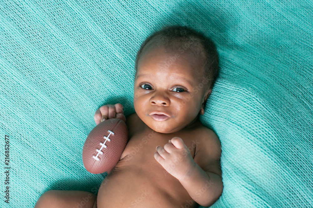 Wall mural Newborn Baby Boy with Football