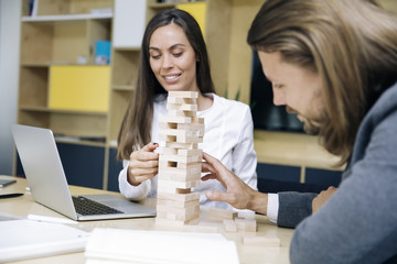 Team of young business people build a wooden construction